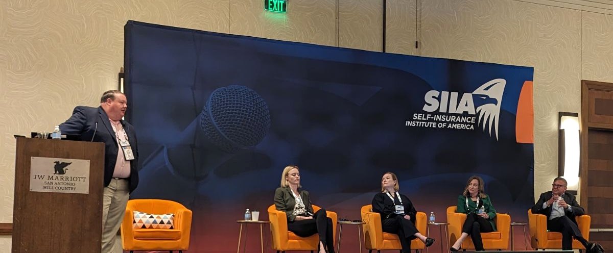 Trey Hinson moderating a panel on stage at SIIA